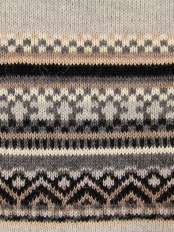 Gros plan de la bordure jacquard en alpaga beige, aux motifs géométriques noirs et marron, design exclusif LaMamita, modèle Angy.