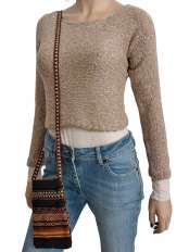 Sur fond blanc, femme avec pull court beige en baby alpaga et coton Pima, modèle Fiona, jean et pochette ethnique péruvienne pour téléphone.